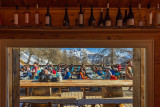 Terrasse du restaurant vue depuis l'intérieur, bois, tables et chaises, vue sur les montagnes enneigées en arrière-plan