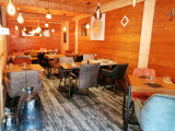 Salle intérieure du restaurant, tables et chaises, ambiance lumineuse et confortable