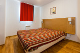 Chambre à coucher avec lit double, fenêtre et rideaux