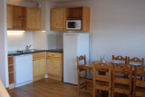 Séjour d'appartement, table à manger, coin cuisine avec plaques électriques, lave-vaisselle, micro-ondes