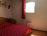 Chambre à coucher avec lit double, ameublement bois, fenêtre