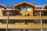 Vue de face des étages supérieurs de la résidence, avec terrasses et fenêtres