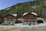 Vue de la résidence, deux bâtiments sur plusieurs étages reliés par une aile centrale avec réception, cadre montagne