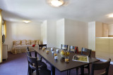 Salon d'appartement avec table à manger, canapé, TV, ameublement bois, fenêtre