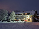 Vue du restaurant en hiver, grande bâtisse en pierre de 3 étages, terrasse extérieure, au fond d'une prairie enneigée