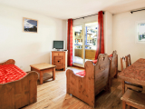 Bright apartment living room with sofa, armchair, coffee table, French doors opening onto a terrace