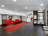 Residence reception area, tiled floor, reception desk, waiting chairs, door to lounge