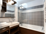 Modern apartment bathrooms with bathtub, sinks, and mirrors