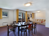 Apartment living room with dining table, sofa, TV, wooden furniture, window