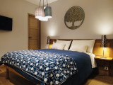 Bedroom with double bed, wooden furniture and TV