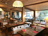 Salle intérieure du restaurant, tables et chaises, ambiance chalet et décor de montagne