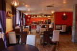 Restaurant dining room, matching white and brown tables and chairs, tiled floor, windows and curtains, red wallpaper
