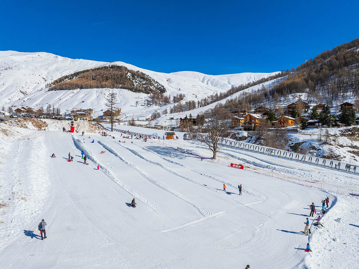 Snow-covered toboggan runs of Val d'Allos - La Foux, resort in the background, Chauvets treadmills nearby