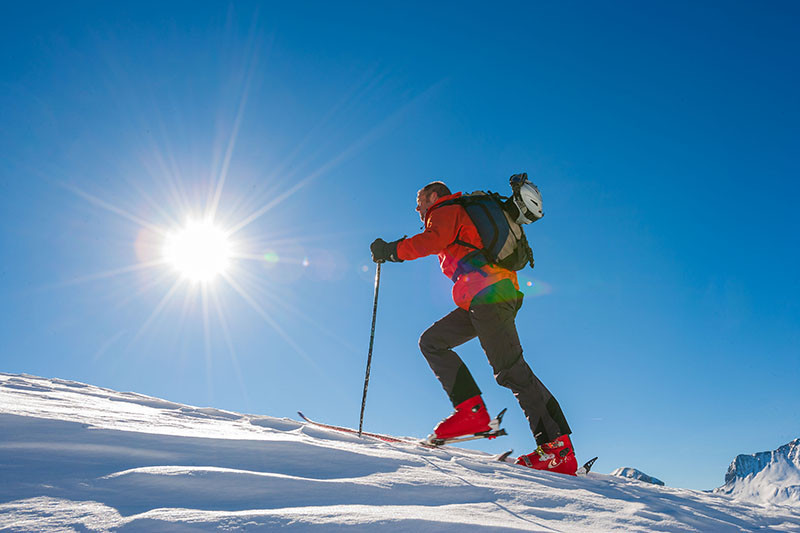 Skieur de randonnée en plein effort sur un sentier enneigé et ensoleillé - © R Palomba office de tourisme du Val d'Allos Skieur de randonnée en plein effort sur un sentier enneigé et ensoleillé