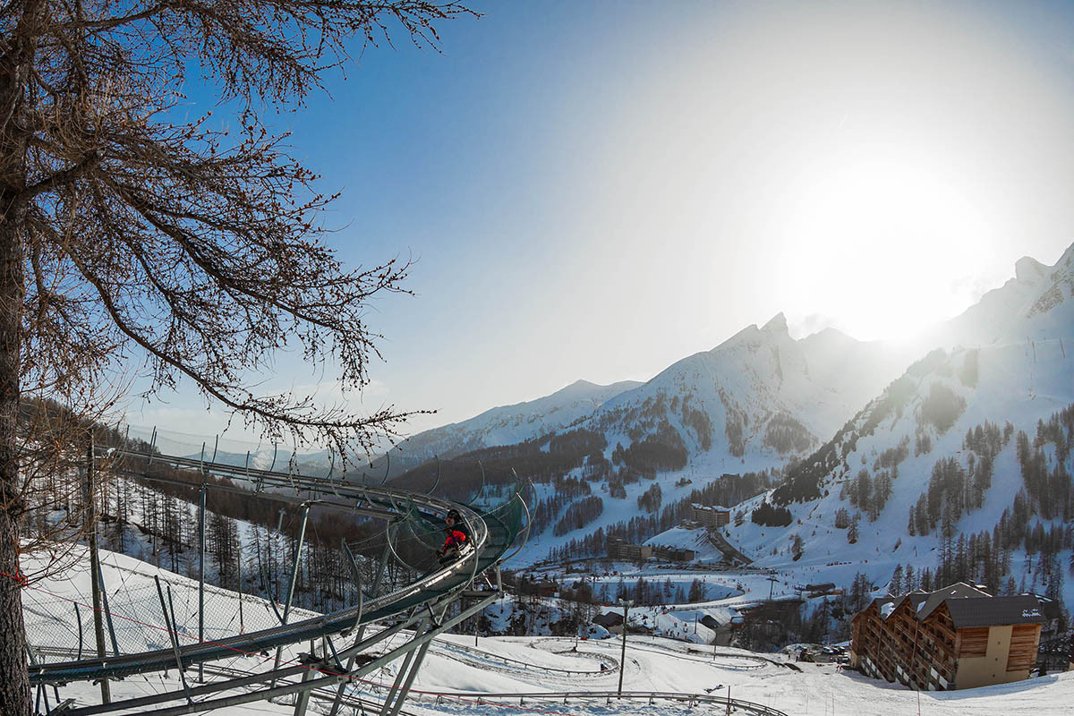 Luge sur rail Verdon Express, nacelle deux places, série de virages en épingle dans un paysage enneigé, vue dégagée sur les montagnes enneigées environnantes