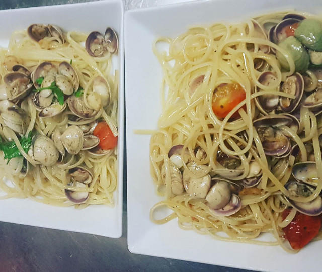 Plats de linguine avec crustacés, tomates cerise et basilic