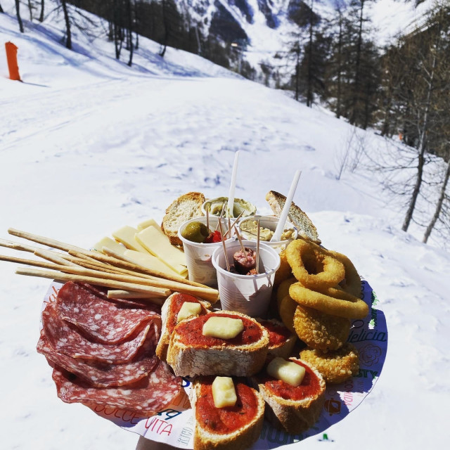 Platter of charcuterie and appetizers with ski slopes in the background