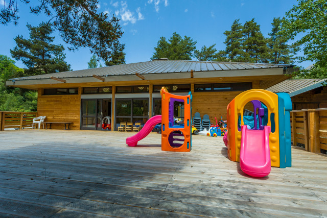 View from the nursery's outdoor terrace, accessible from the building, with slides and children's play equipment.