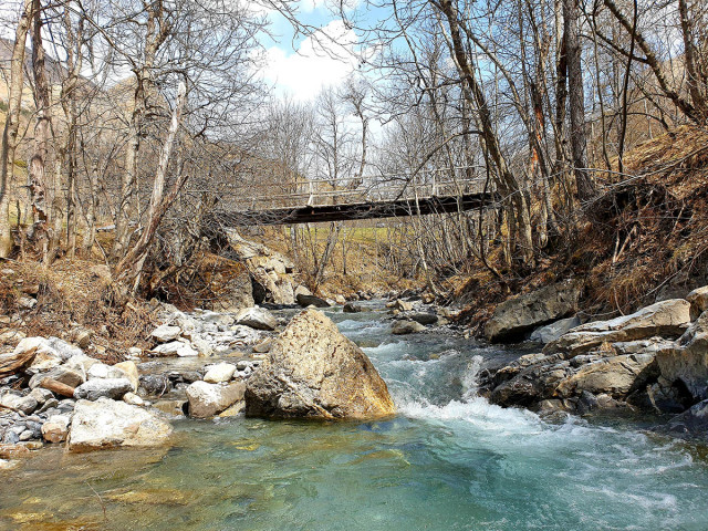 Passerelle du Hameau de Bouchier passant sur le cours d'eau du même nom, eau claire passant entre les rochers au milieu d'une forêt en hiver - © office de tourisme du Val d'Allos CB Passerelle du Hameau de Bouchier passant sur le cours d'eau du même nom, eau claire passant entre les rochers au milieu d'une forêt en hiver
