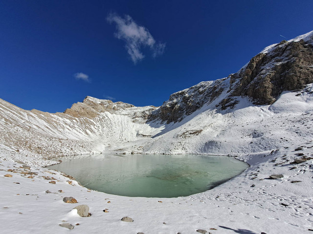 A vast expanse of water at the start of winter, with snow all around