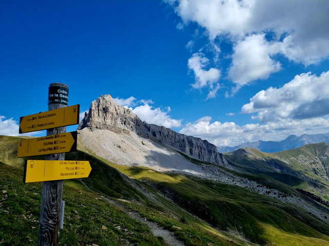 Mountain panorama from the e-bike trail sign located at the Crête de Sestrière, 2490m altitude. Rocky mountainside and meadows. - © B Courbon Mountain panorama from the e-bike trail sign located at the Crête de Sestrière, 2490m altitude. Rocky mountainside and meadows.
