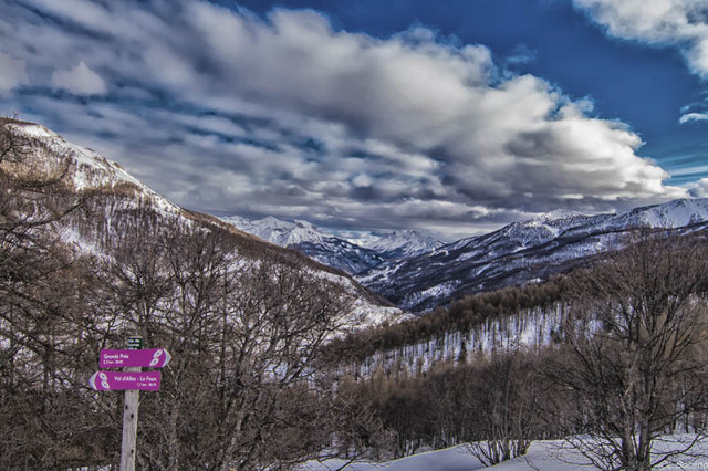 Vue des montagnes et des forêts enneigées de Val d'Allos - La Foux depuis un panneau violet de l'itinéraire de randonnée raquettes des Grands Prés