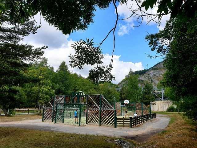 City stadium in the middle of a wooded area, enclosed football and basketball court