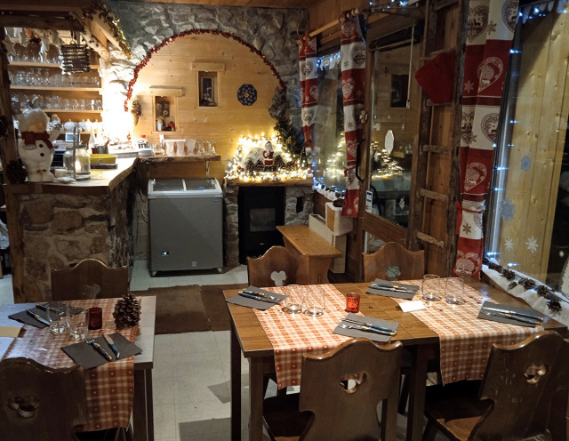 Interior of the crêperie, Christmas decorations, wood and stone, dining tables and chairs