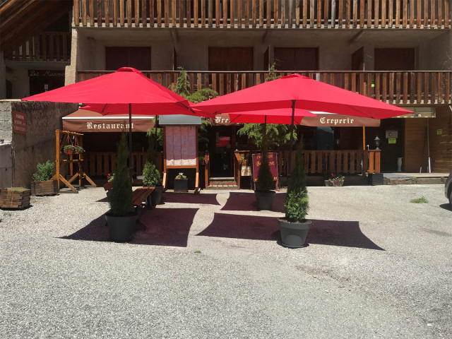 View from the crêperie terrace in summer, terrace with parasols and benches