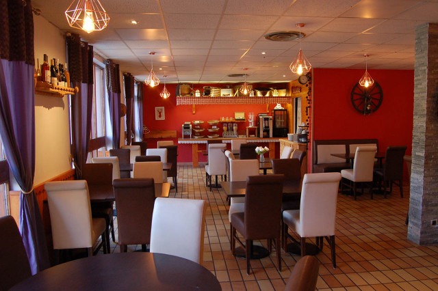 Salle de restaurant, tables et chaises assorties blanches et marron, carrelage au sol, fenêtres et rideaux, papier peint rouge