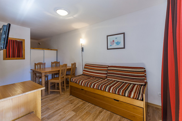Séjour d'appartement avec canapé-lit, table à manger, TV murale - © Les cimes du Val d'Allos Séjour d'appartement avec canapé-lit, table à manger, TV murale