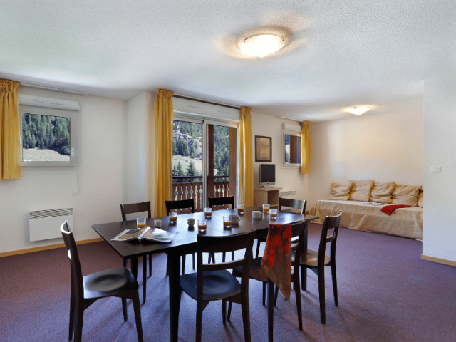 Apartment living room with dining table, sofa, TV, wooden furniture, window