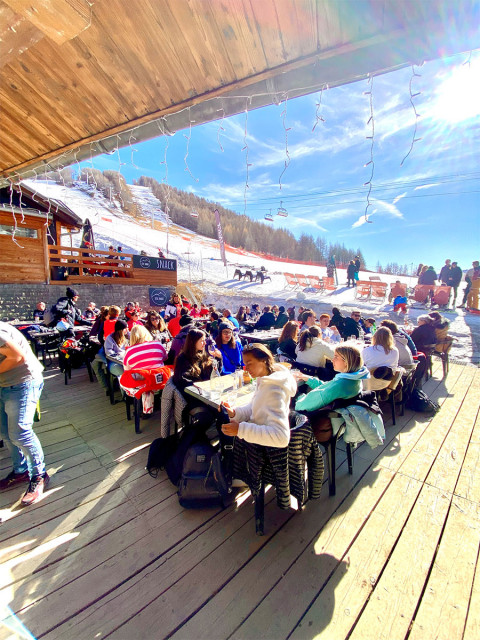 Sunny restaurant terrace, tables and chairs, access to the snowy slopes, chairlift nearby