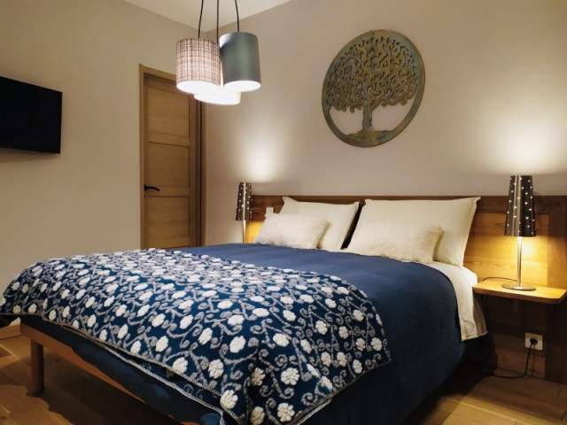 Bedroom with double bed, wooden furniture and TV