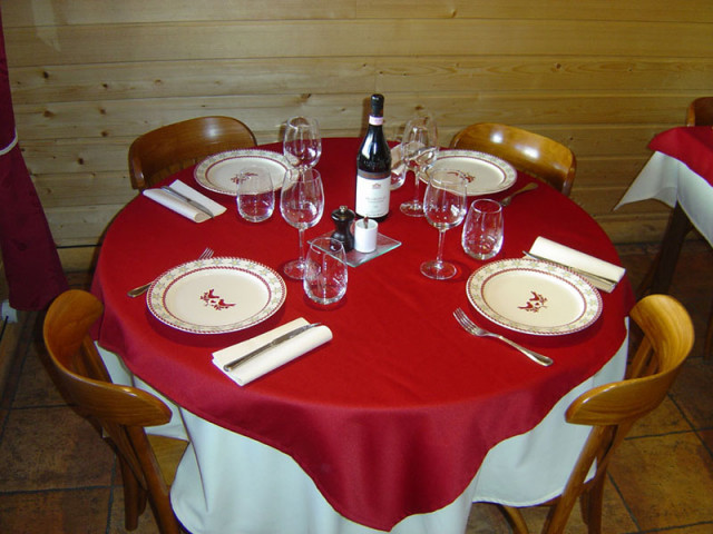 Table ronde de restaurant, nappe rouge, service Table ronde de restaurant, nappe rouge, service
