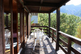 Wooden balcony with table and chairs, view of the mountains
