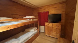 Bedroom with large bunk beds, television, wooden furniture, parquet flooring, window