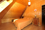 Bright bedroom in the attic, wood interior, double bed, wooden furniture, window