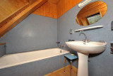 Bathroom with bathtub, sink, mirror, and wood interior