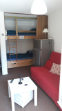 View of the studio's bedroom area, sofa, coffee table, bunk beds