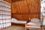 chambre à coucher d'enfant lumineuse sous combles avec deux lits simples et fenêtre