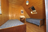 Bright attic bedroom with two single beds, skylight, wooden furniture, wood interior