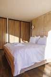 Large and bright bedroom, wood furniture, double bed, parquet flooring