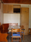 Living room with wooden furniture, dining table, storage space, television, tiled floor