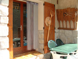 Outdoor terrace of a house made out of stone, outdoor table, french window