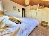 Chambre à coucher lumineuse avec lit double, ameublement bois, parquet au sol