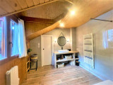 Salle de bains lumineuse avec grand bac à douche, ameublement bois, radiateur, parquet au sol, fenêtre