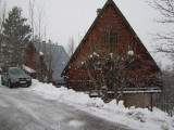 wooden chalet with balcony, window, snowy landscape