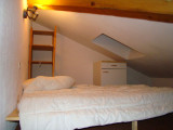 Attic bedroom with double bed, wooden furniture, storage space