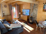 Bright living room with sofa, wooden furniture, wood stove, windows and curtains